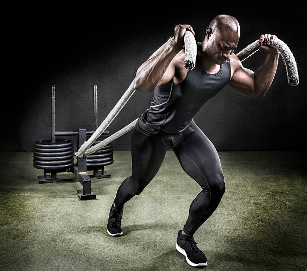 Athlete pulling weight sled in gym.