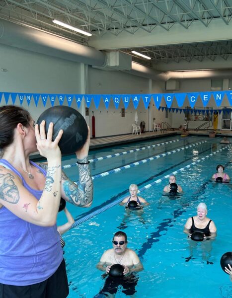 person holding a ball with people in the water