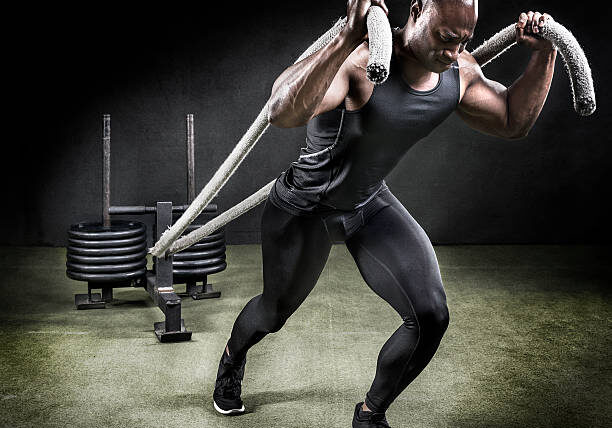 Athlete pulling weight sled in gym.