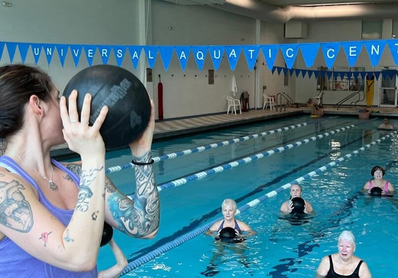 person holding a ball with people in the water